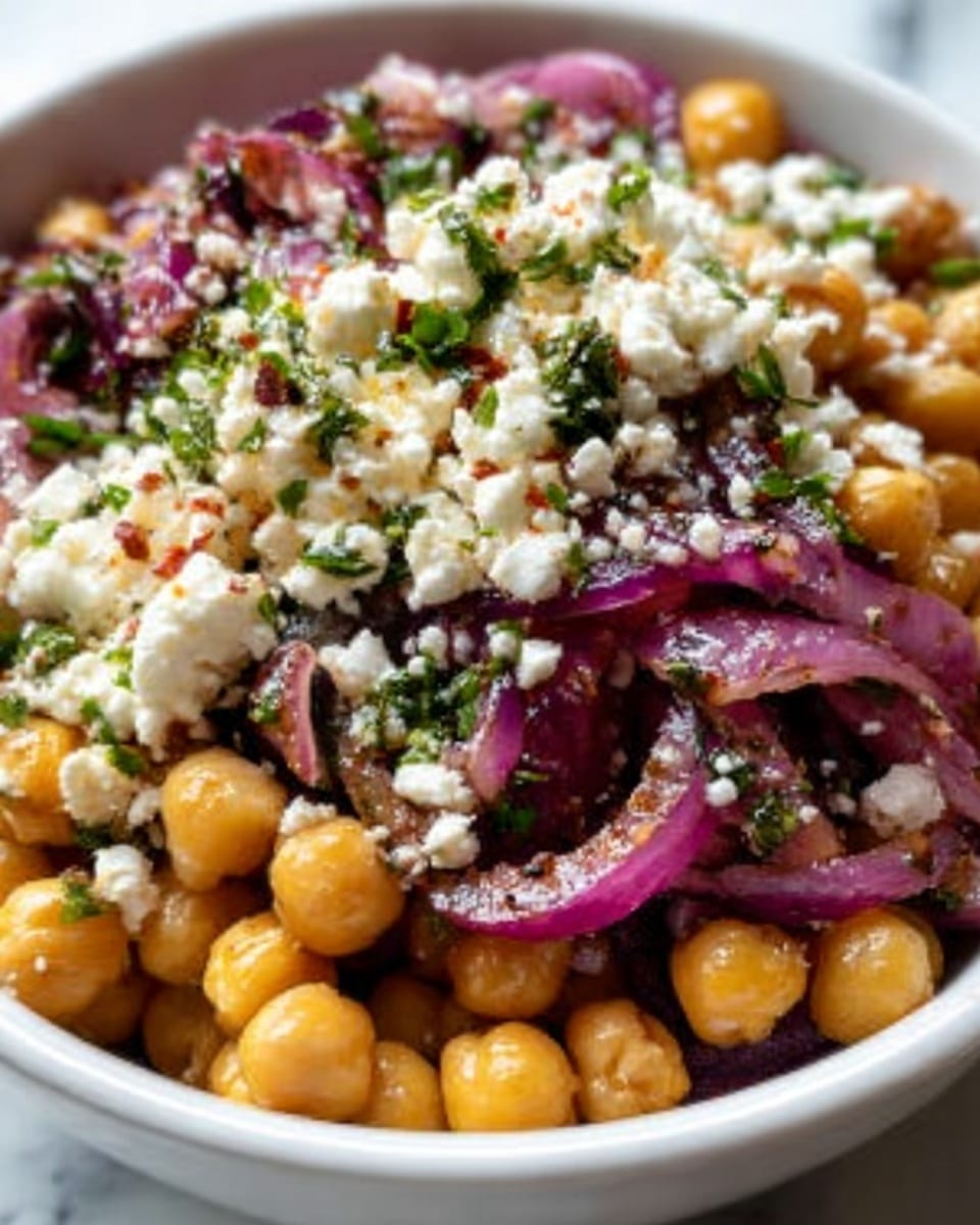 A white bowl filled with a salad made of three main layers: the base is round, light beige chickpeas mixed with dark black beans, giving a contrast of light and dark colors; the middle layer is bright green chopped herbs scattered evenly; the top layer consists of small white crumbles of cheese and thin slices of pale purple onions spread across, adding texture and color contrast. The salad glistens with a light dressing, sitting on a white marbled surface near a window with soft natural light shining. photo taken with an iphone --ar 4:5 --v 7
