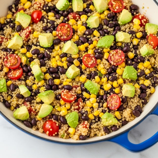 A close-up view of a dish made of small cooked quinoa grains mixed with black beans, yellow corn kernels, and chopped red tomatoes. There are pieces of green avocado and bits of herbs scattered throughout. The mixture looks moist and colorful, with a wooden spoon scooping out a portion from the middle of the dish. The texture shows a mix of soft grains and crunchy vegetables, all sitting on a white marbled surface. photo taken with an iphone --ar 4:5 --v 7