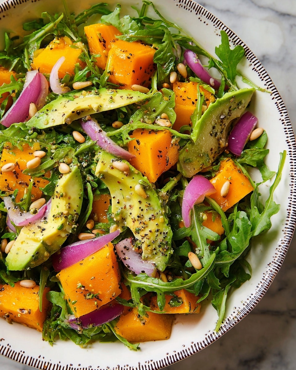 A white bowl holds a fresh salad arranged in three main layers: the bottom layer is bright green arugula leaves with a slightly jagged texture, the middle layer is made up of thick slices and chunks of smooth yellow-orange mango and creamy pale green avocado wedges, and the top layer consists of thin, slightly shiny purple-red onion slices and scattered light brown toasted pine nuts. The salad is lightly seasoned with coarse black pepper and small green herb bits, all resting on a white marbled surface. photo taken with an iphone --ar 4:5 --v 7