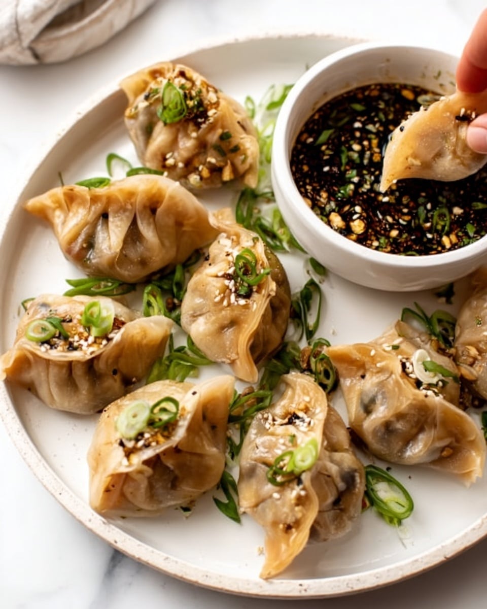 A white plate on a white marbled surface holds a circle of seven golden-brown dumplings with soft, slightly shiny wrappers that are crimped and have light green chopped spring onion and sesame seed sprinkles on them. In the center of the plate is a small white bowl filled with dark soy dipping sauce mixed with finely chopped orange garlic, green herbs, and small white sesame seeds. The scattered light green spring onion slices and small herb pieces add fresh color around the dumplings. photo taken with an iphone --ar 4:5 --v 7