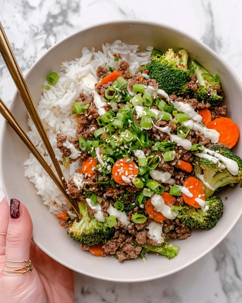 A white bowl with a brown rim holds a layered dish starting with a base layer of fluffy white rice. On top, there is a colorful mix of cooked ground beef, bright green broccoli pieces, and sliced orange carrots scattered evenly. The dish is garnished with chopped green onions, a drizzle of light creamy sauce, and some sesame seeds on top. A long gold spoon is placed resting inside the bowl. Nearby, two small white bowls contain chopped green onions and sesame seeds, all set on a white marbled surface with a gold fork and soft white cloth beside it. Photo taken with an iphone --ar 4:5 --v 7